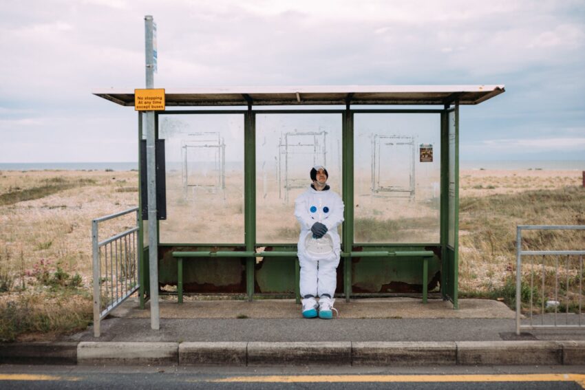person in a space suit waiting at the bus stop